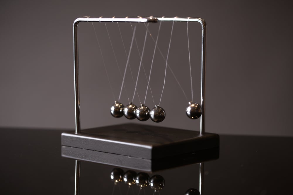 Closeup,metal,newton,cradle,placed,on,gray,background,as,representation