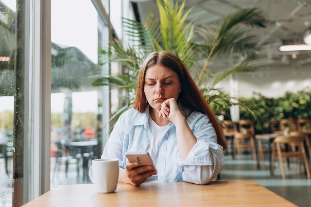 Portrait,of,sad,young,redhead,woman,in,a,coffee,shop