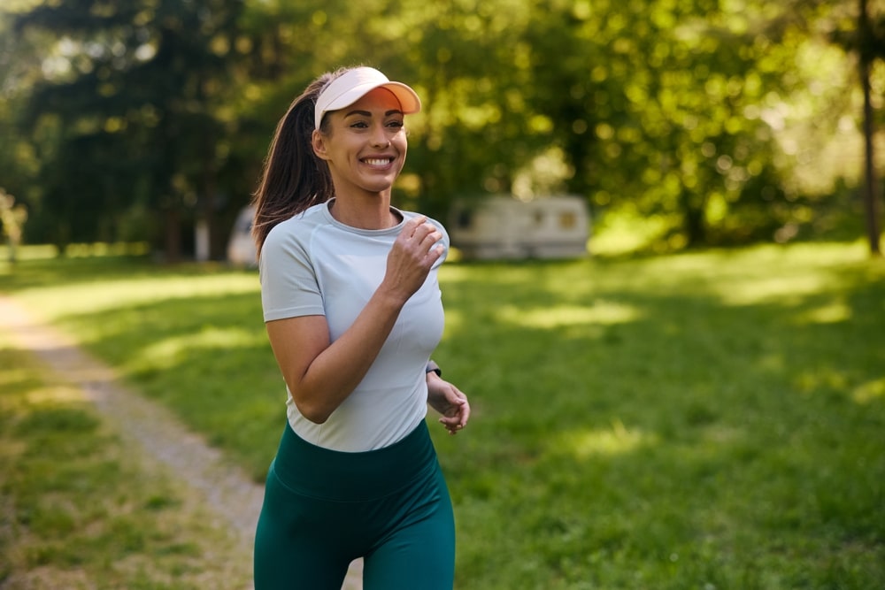 Happy,athletic,woman,running,while,exercising,in,nature.,copy,space.