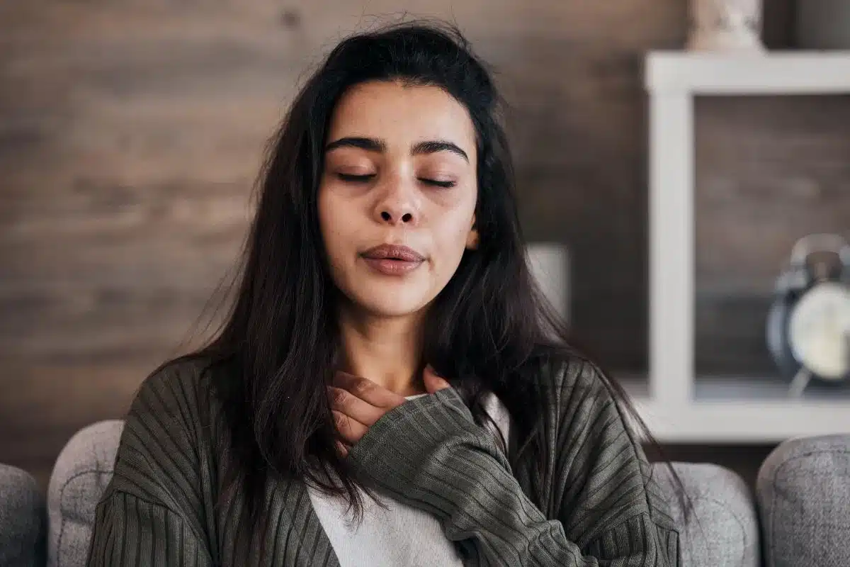 Person pausing at a window and breathing slowly to regain calm during a moment of anger