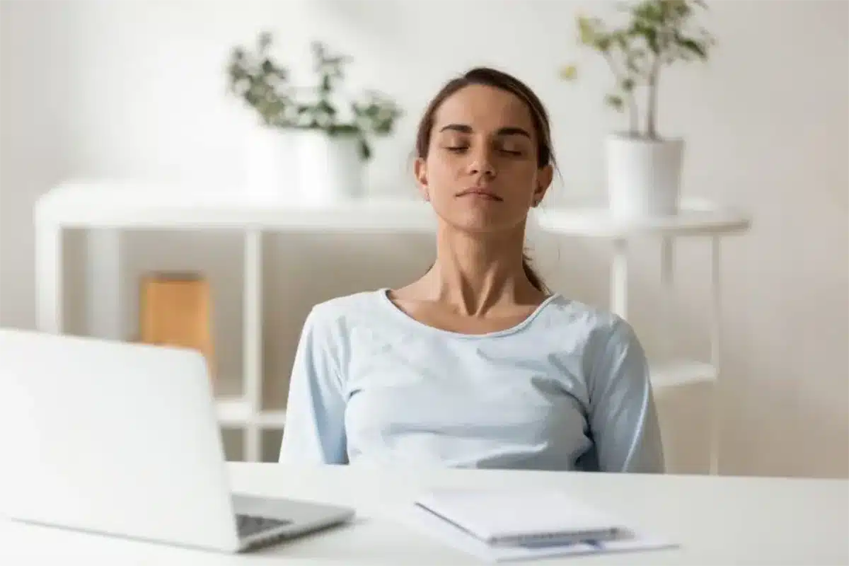 Person taking slow box breaths by a computer to stop an anger outburst